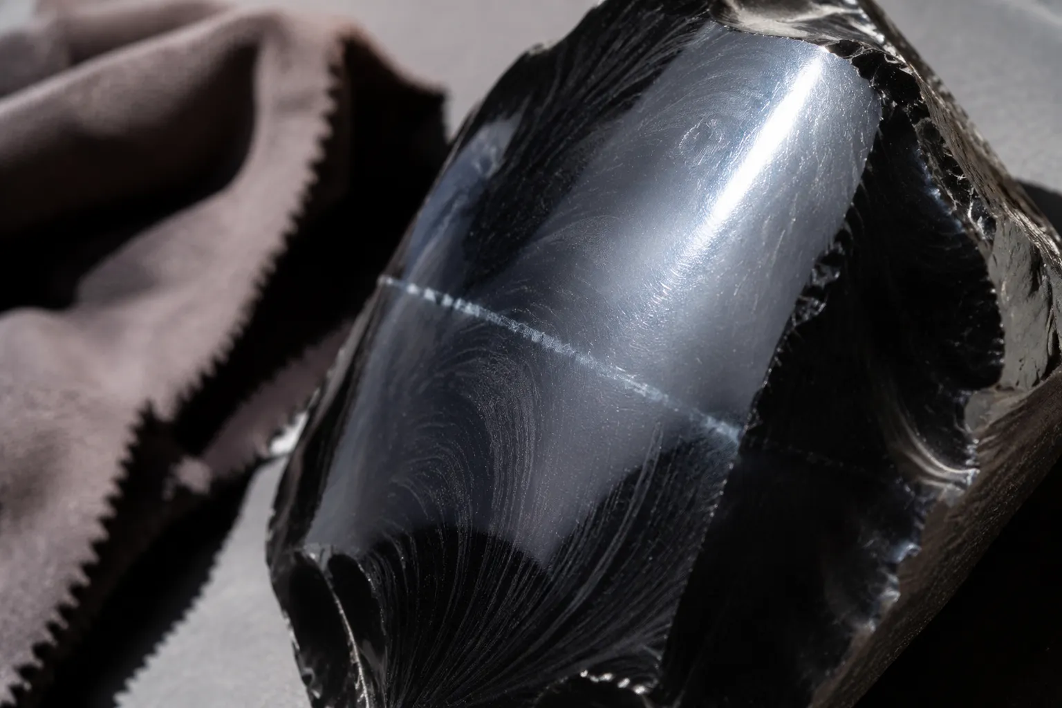 Polished obsidian inspected under angled light for haze and water residue