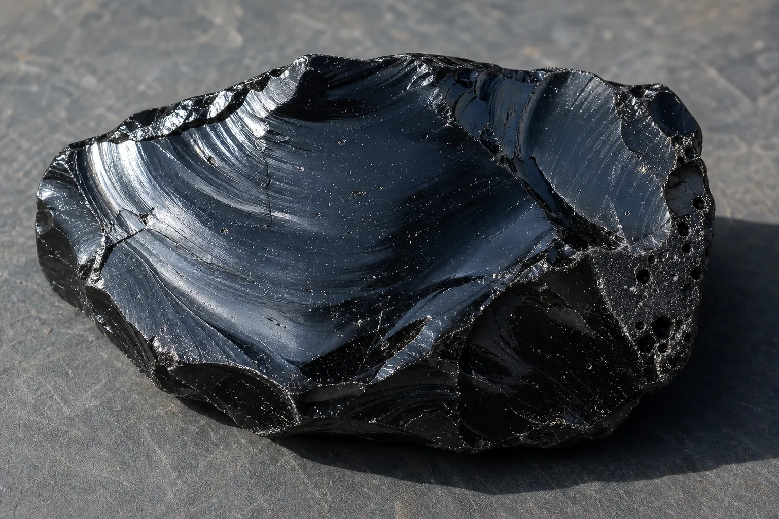 Dense obsidian showing sparse vesicles and glassy texture