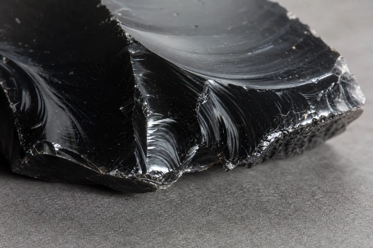 Chipped black obsidian edge showing curved glassy fracture
