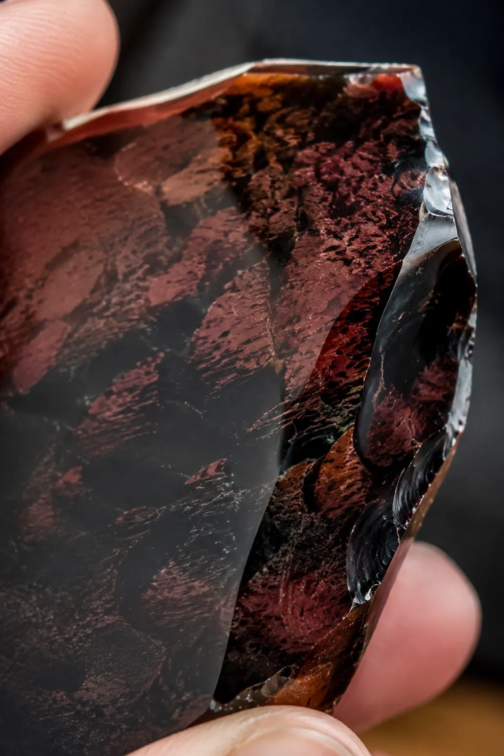 Close view of mahogany obsidian showing red-brown pattern depth and a glassy edge